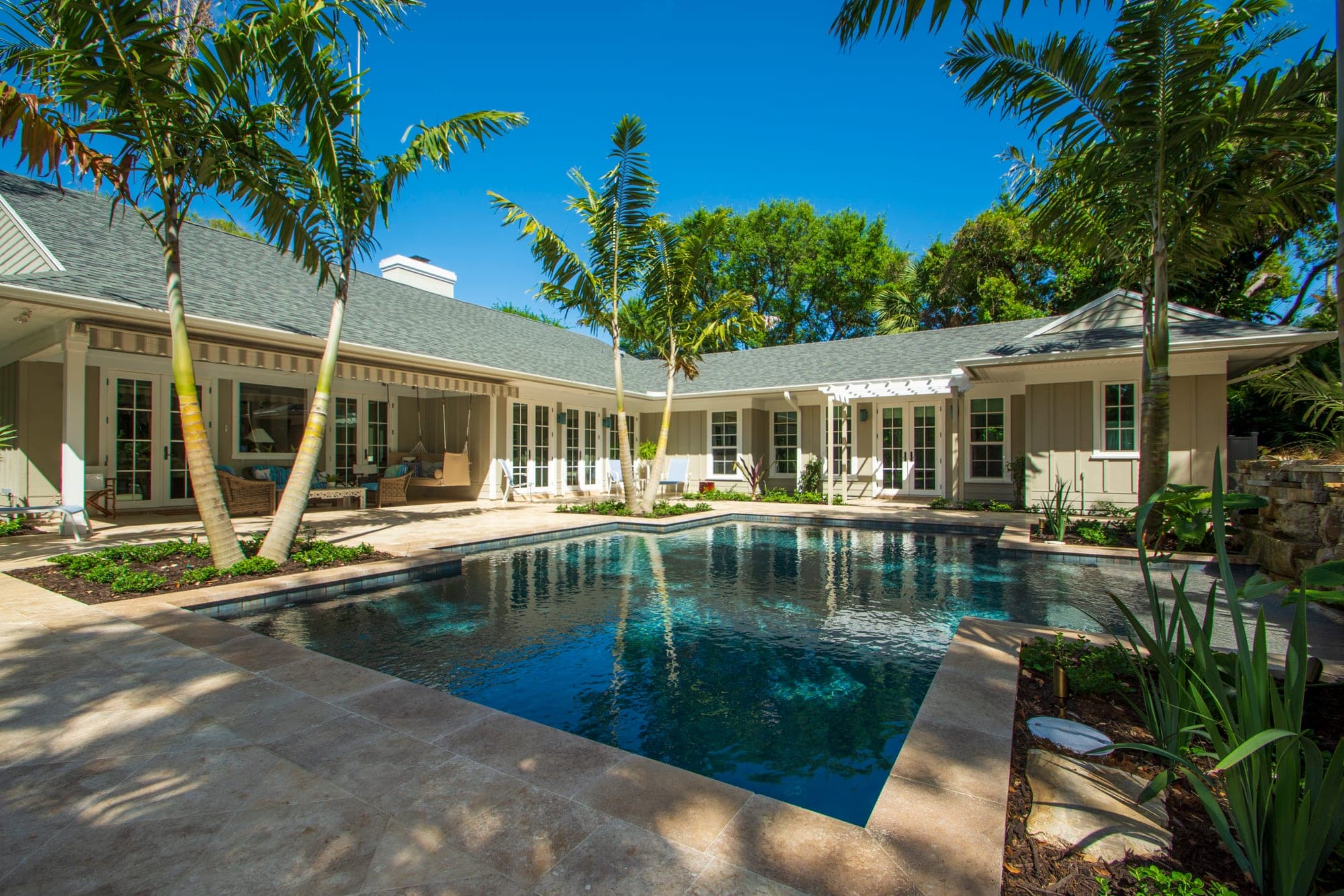 Remodeled pool terrace framed by the home's L-shaped covered porch in Central Beach & Riomar, Vero Beach by Builders East